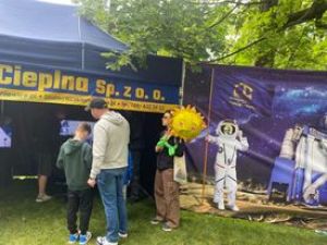 Grupa ludzi przed granatowym namiotem