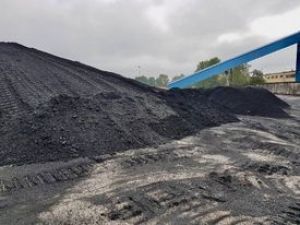 Pryzma węgla w tle widoczny niebiesko - stalowy budynek Energetyki Cieplnej
