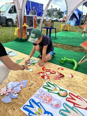 Chłopiec w granatowej koszulce układa kolorowe puzzle