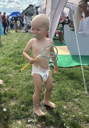 Małe dziecko w pieluszce stoi na trawie