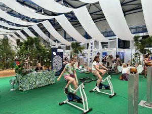 Dwie dziewczynki jeżdżą na elektrycznych rowerach, które stoja na zielonym dywanie