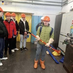 Chłopiec przymierza odzież roboczą.