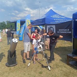 Stoisko obserwacji astronomicznych, gdzie chłopiec patrzy przez lunetę